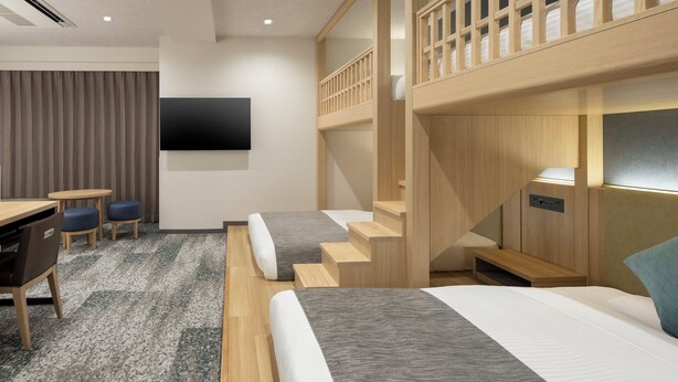 A modern hotel room with a bunk bed, a desk with two chairs, a flat-screen TV, and a staircase. - HOTEL MYSTAYS Iidabashi (Tokyo)