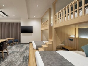 A modern hotel room with a bunk bed, a desk with two chairs, a flat-screen TV, and a staircase. - HOTEL MYSTAYS Iidabashi (Tokyo)