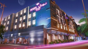 Un hotel con un letrero llamativo, varios pisos y una fachada bien iluminada.