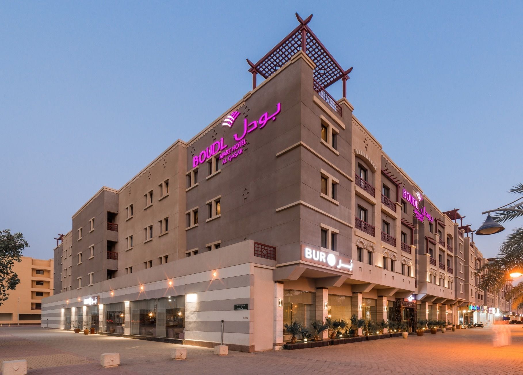 Un hotel de diseño moderno, con un llamativo letrero de neón y una estructura en la azotea.