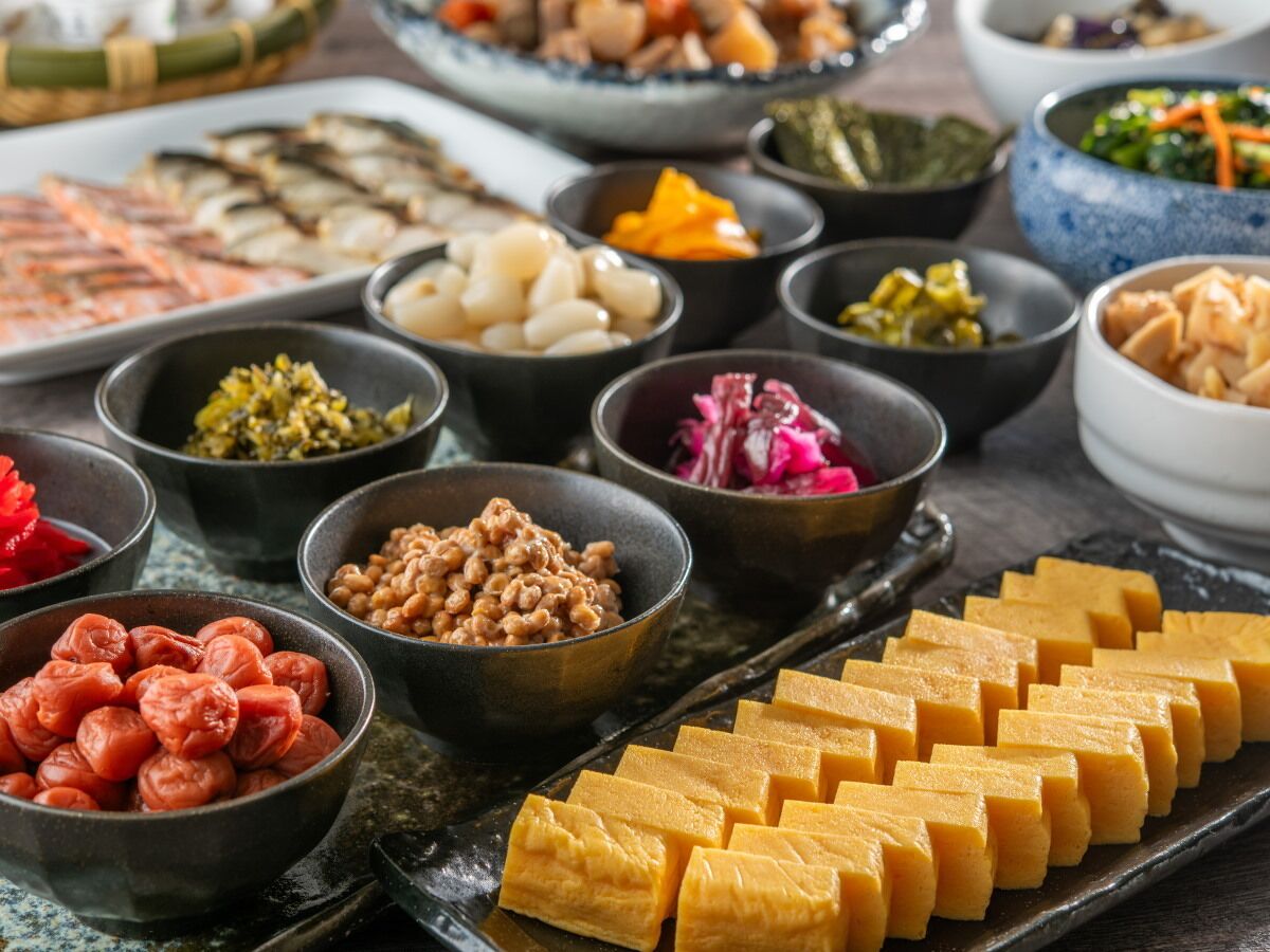 A variety of dishes arranged on a table, including tofu, beans, and pickled vegetables.