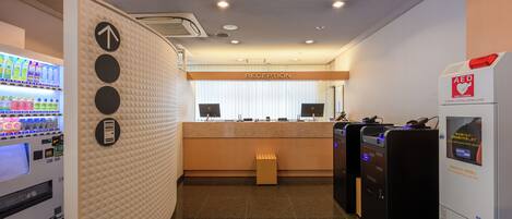 A reception area with a reception desk, a vending machine, and AED emergency defibrillators.