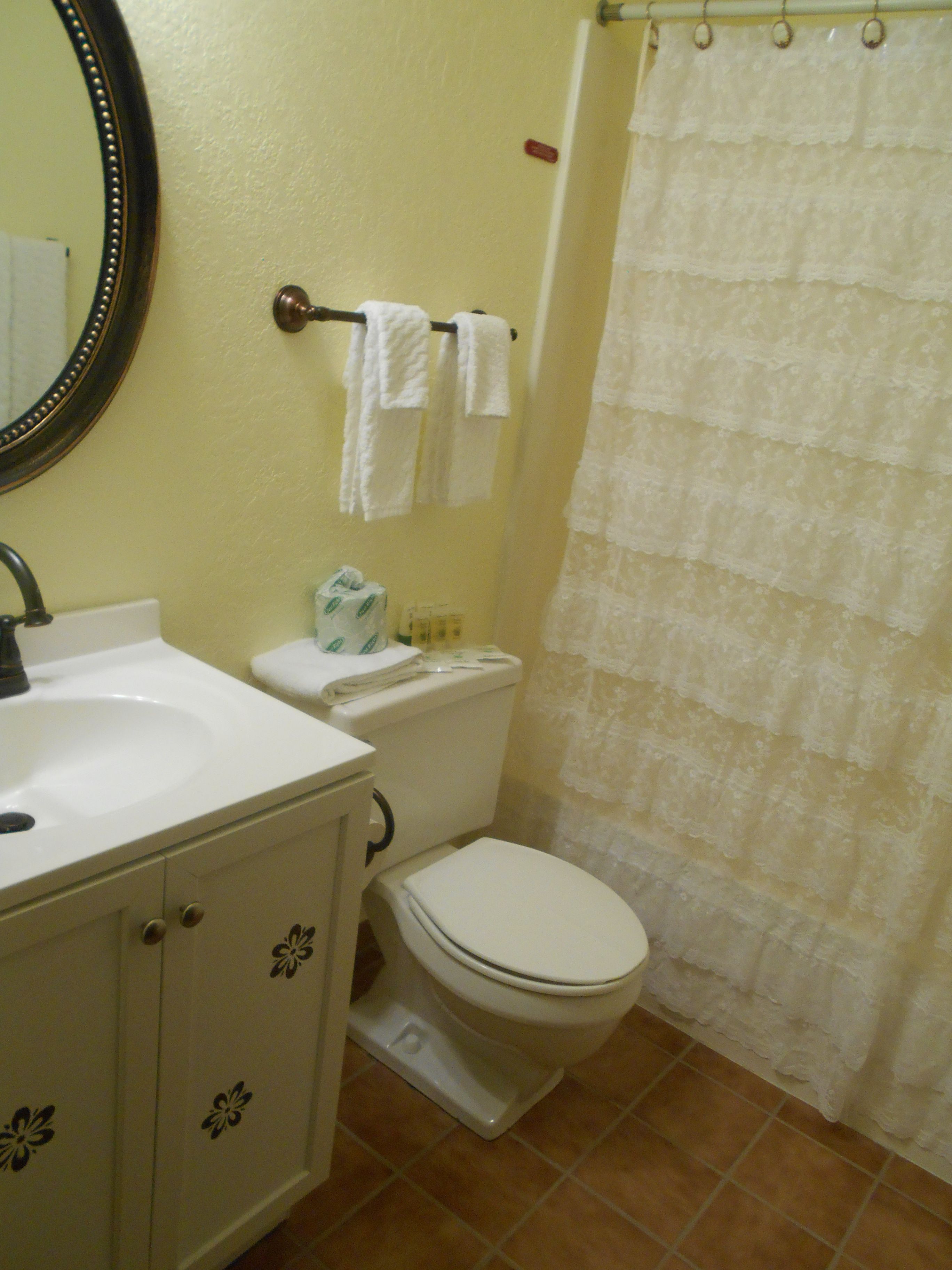 A bathroom with a white sink, toilet, and shower curtain.