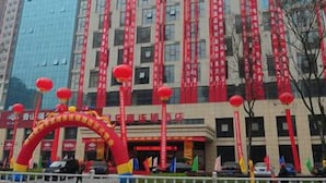 Un bâtiment à étages, orné de banderoles rouges et surmonté d’une arche rouge décorée de drapeaux.