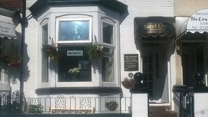 A corner building with a 'Vacancies' sign, a 'Hazel Grove' sign, and a 'Rooms Suite' sign.