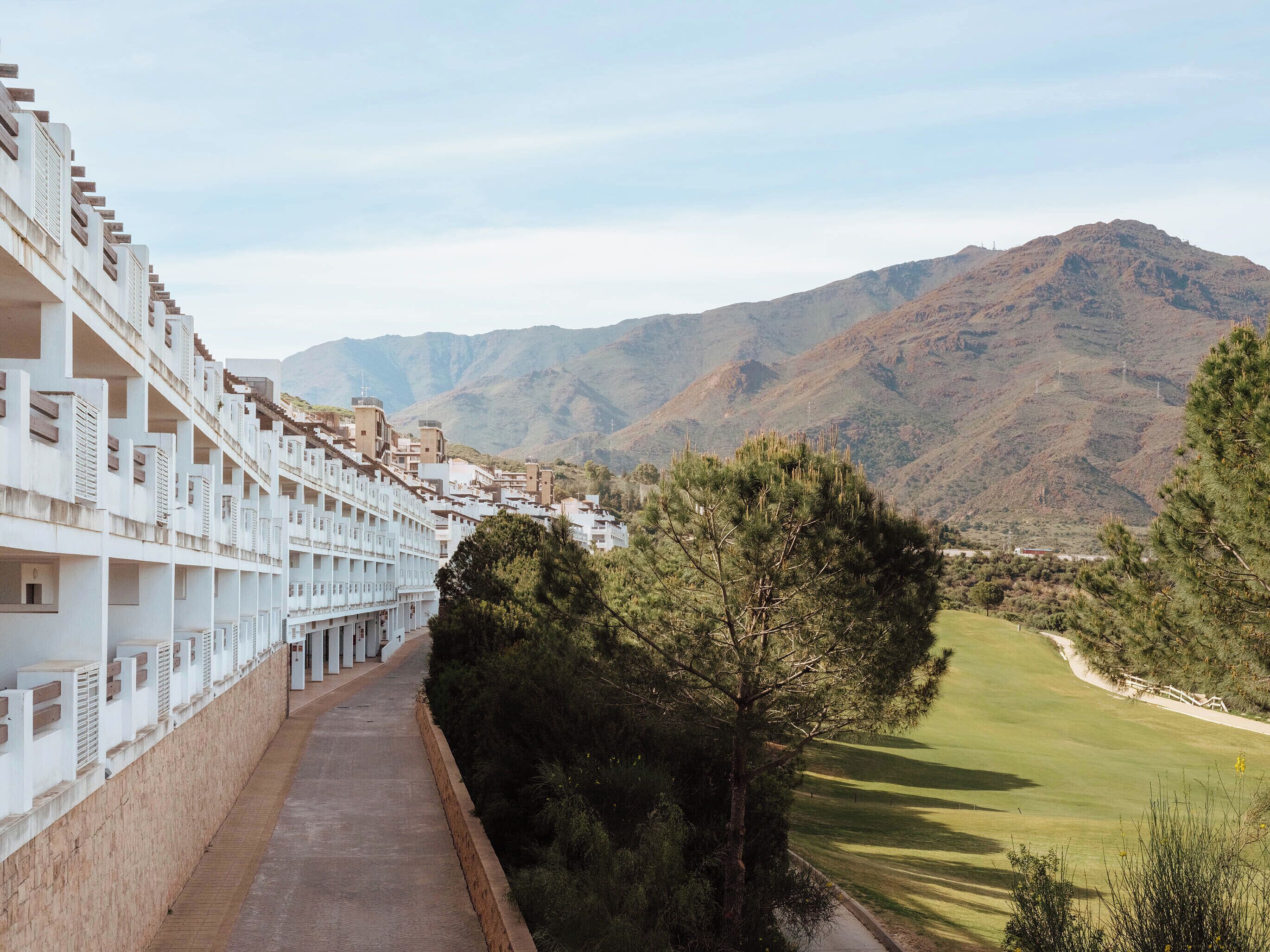 Un hôtel doté d’un long couloir et de balcons donnant sur un paysage montagneux.