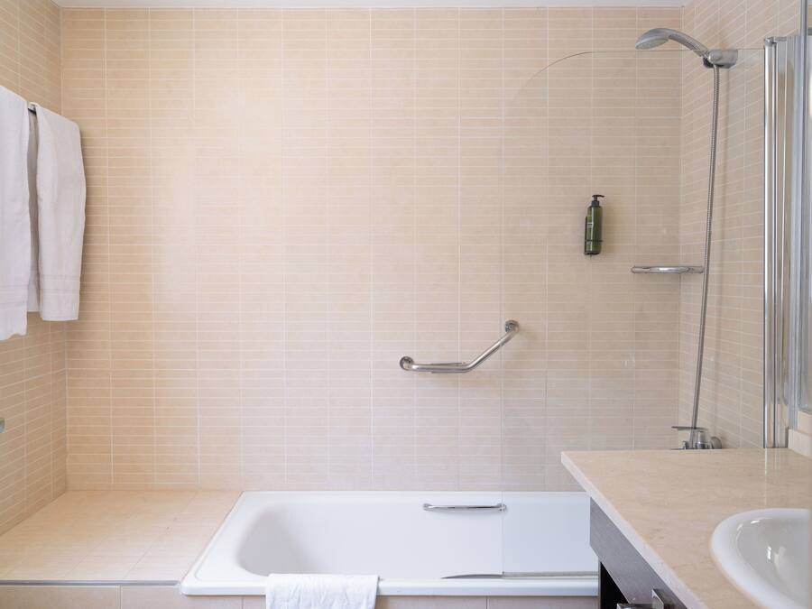 Un baño con bañera, ducha y lavamanos.