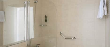 A bathroom with a sink, mirror, shower, and bathtub.
