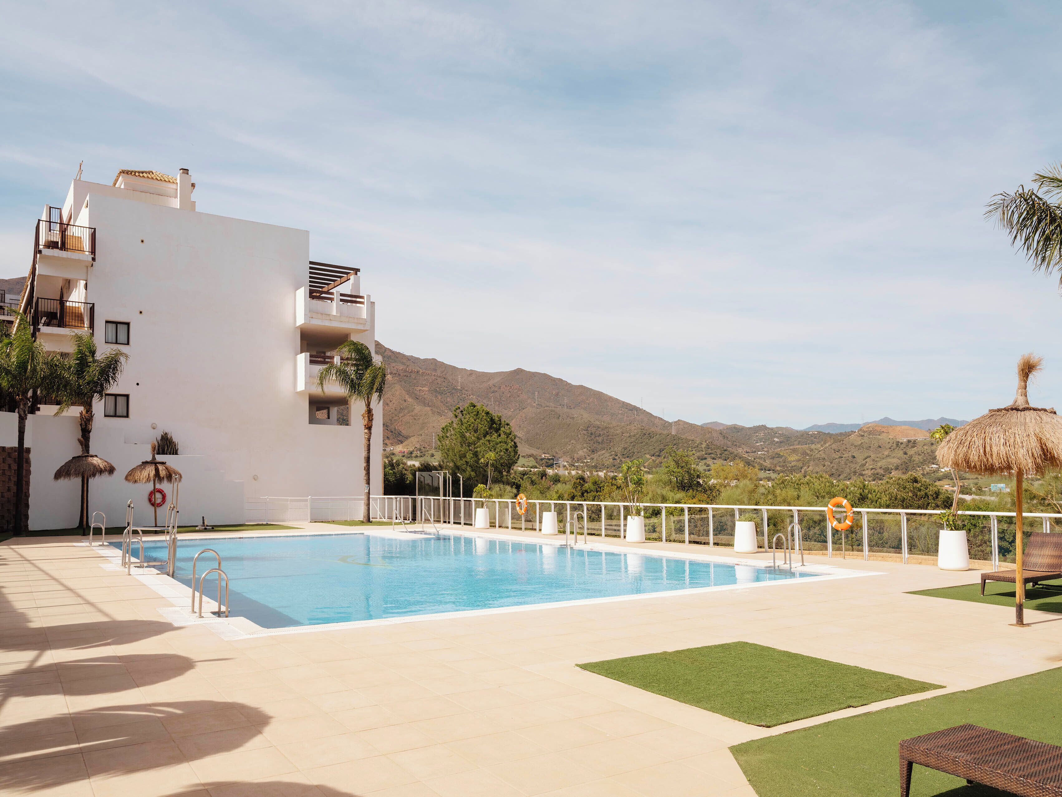 Una piscina al aire libre de temporada, tumbonas