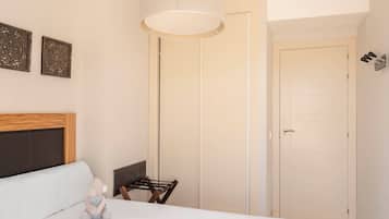 Une chambre à coucher avec un lit, une chaise, une lampe et une porte.
