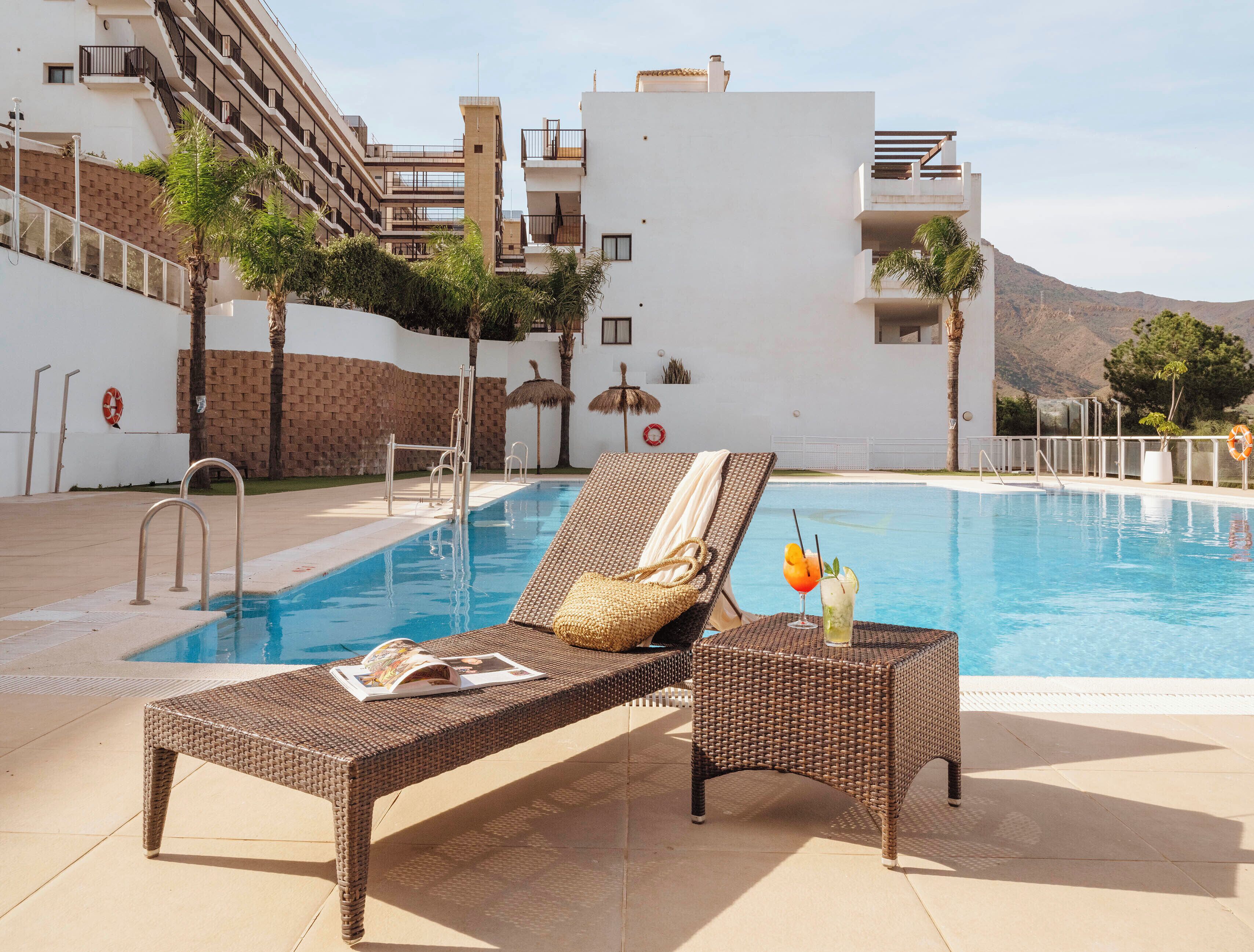 Una piscina al aire libre de temporada, sillones reclinables de piscina