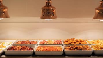 Un bufé con diversos alimentos, como huevos, carnes y pasta.