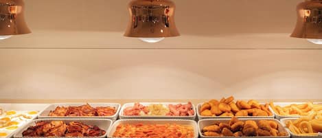 A buffet with various food items including eggs, meats, and pasta.