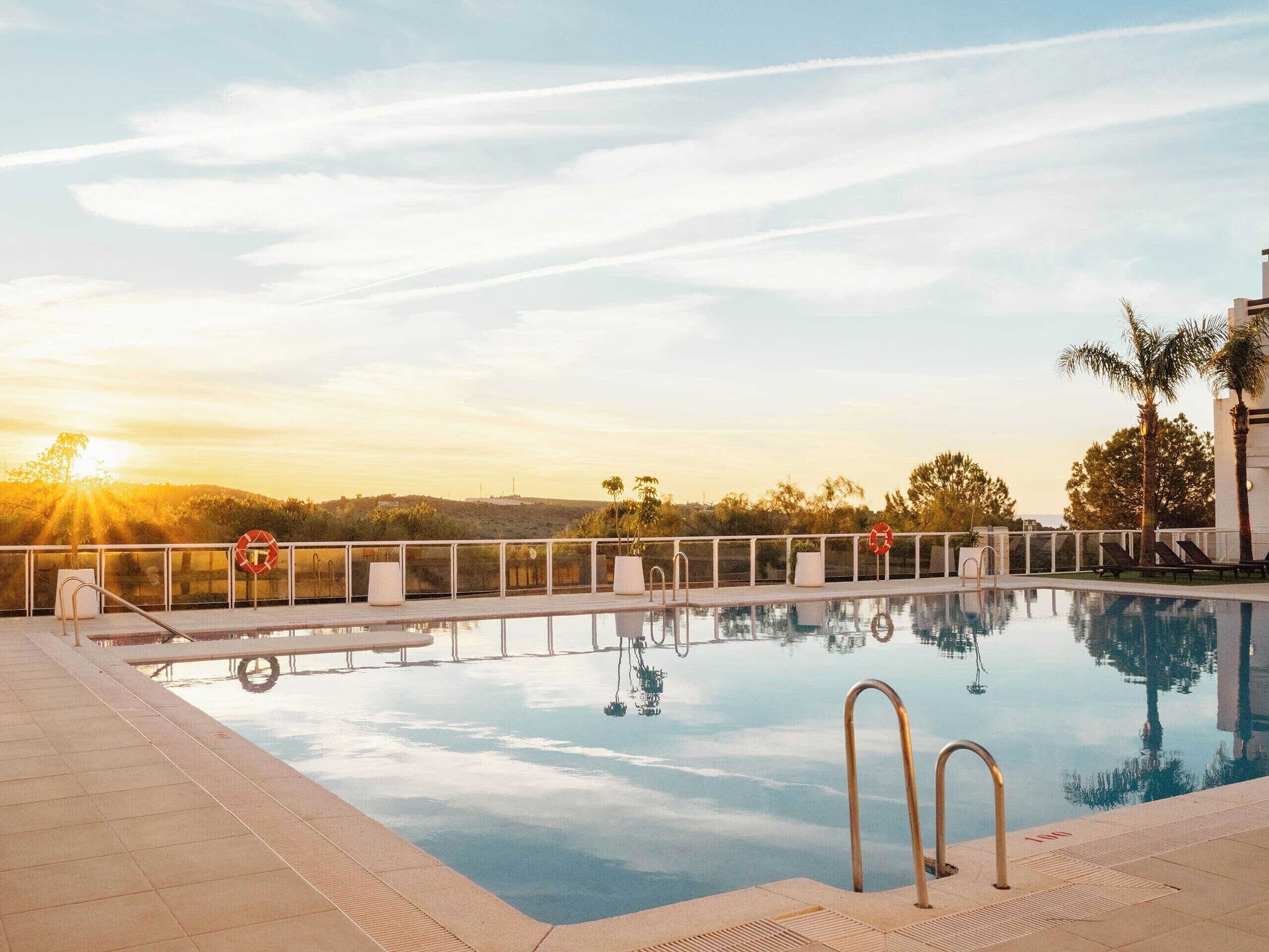 Una piscina al aire libre de temporada, tumbonas