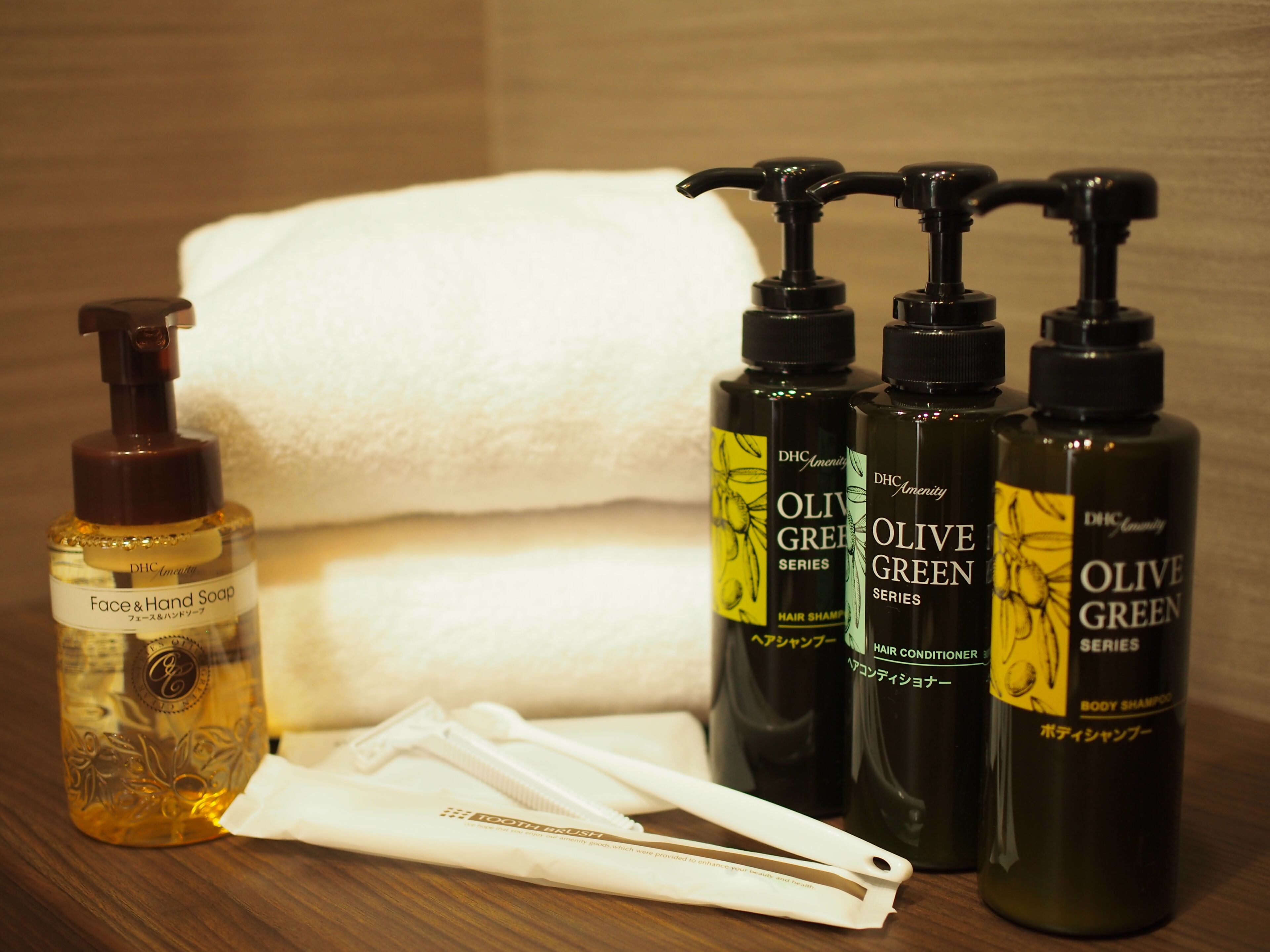 Toiletries including face and hand soap, hair shampoo, and body shampoo, along with a toothbrush and a towel.