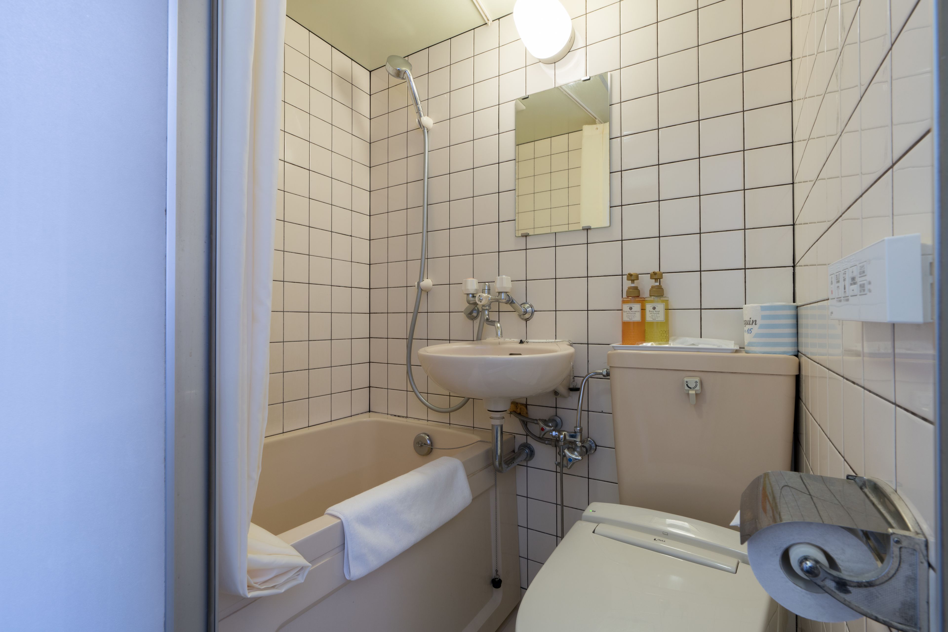 A bathroom with a bathtub, sink, toilet, and a mirror.