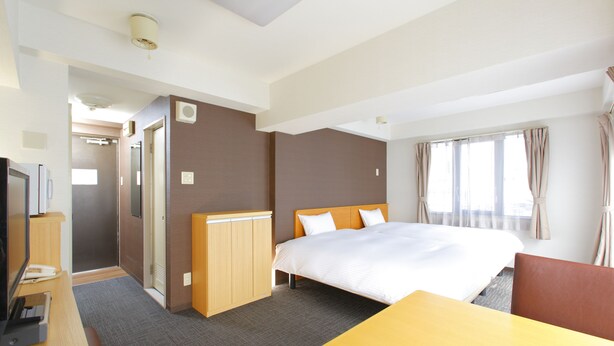 A hotel room with a bed, a desk, a chair, a television, and a wardrobe. - Flexstay Inn Shirogane (Tokyo)