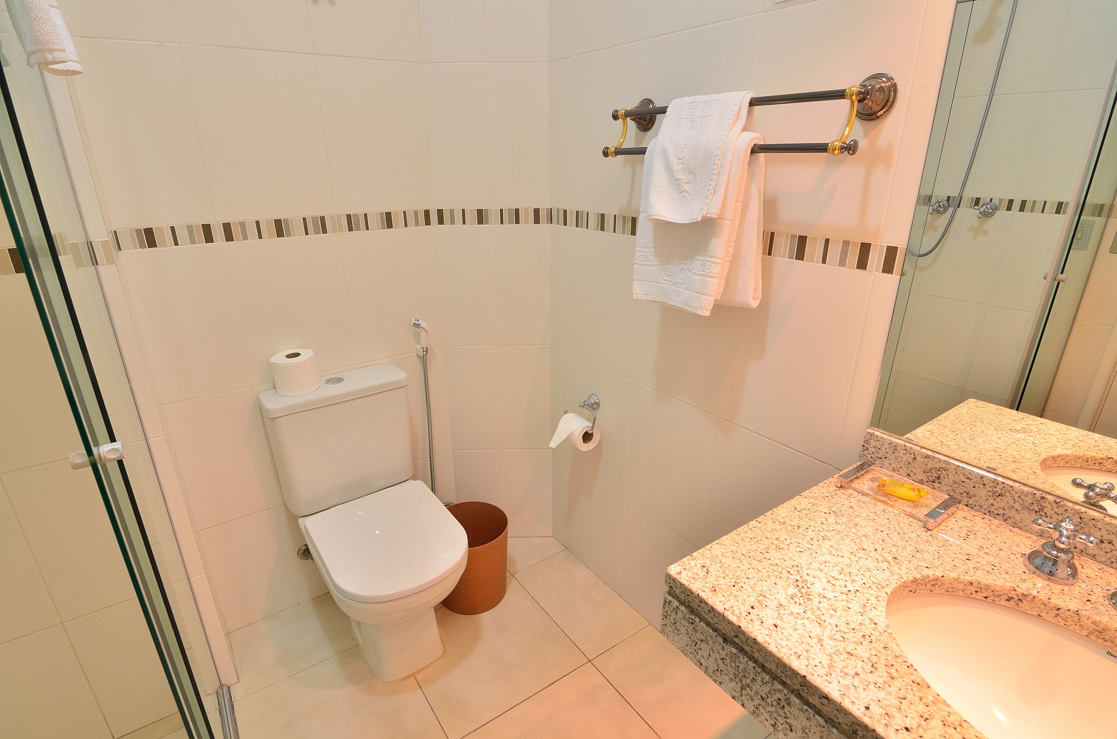 Une salle de bain équipée de toilettes, d’un bidet et d’un lavabo.