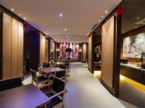 A restaurant interior with wooden paneling, tables, chairs, and a television screen.