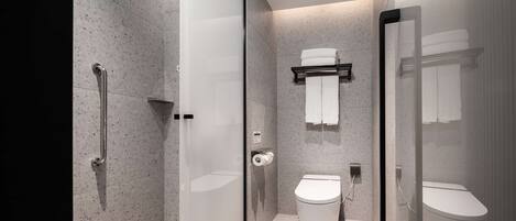 A modern bathroom with a glass shower enclosure, a toilet, and a towel rack.