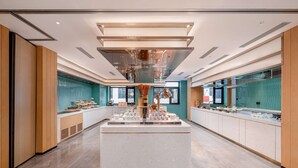 A modern hotel lobby with a central island, wooden paneling, and a teal accent wall. - Hilton Garden Inn Beijing Temple of Heaven East Gate Station (Beijing)