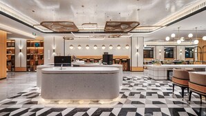 A modern lobby with a central reception desk, seating areas, and a patterned floor. - Hilton Garden Inn Beijing Temple of Heaven East Gate Station (Beijing)