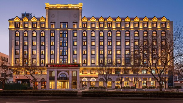 A large, multi-story hotel with a classic architectural style, featuring a prominent entrance and multiple windows. - Hilton Garden Inn Beijing Temple of Heaven East Gate Station (Beijing)