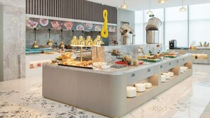 Une cuisine moderne dotée d’un îlot central, d’un four encastré et d’une variété de produits alimentaires exposés.