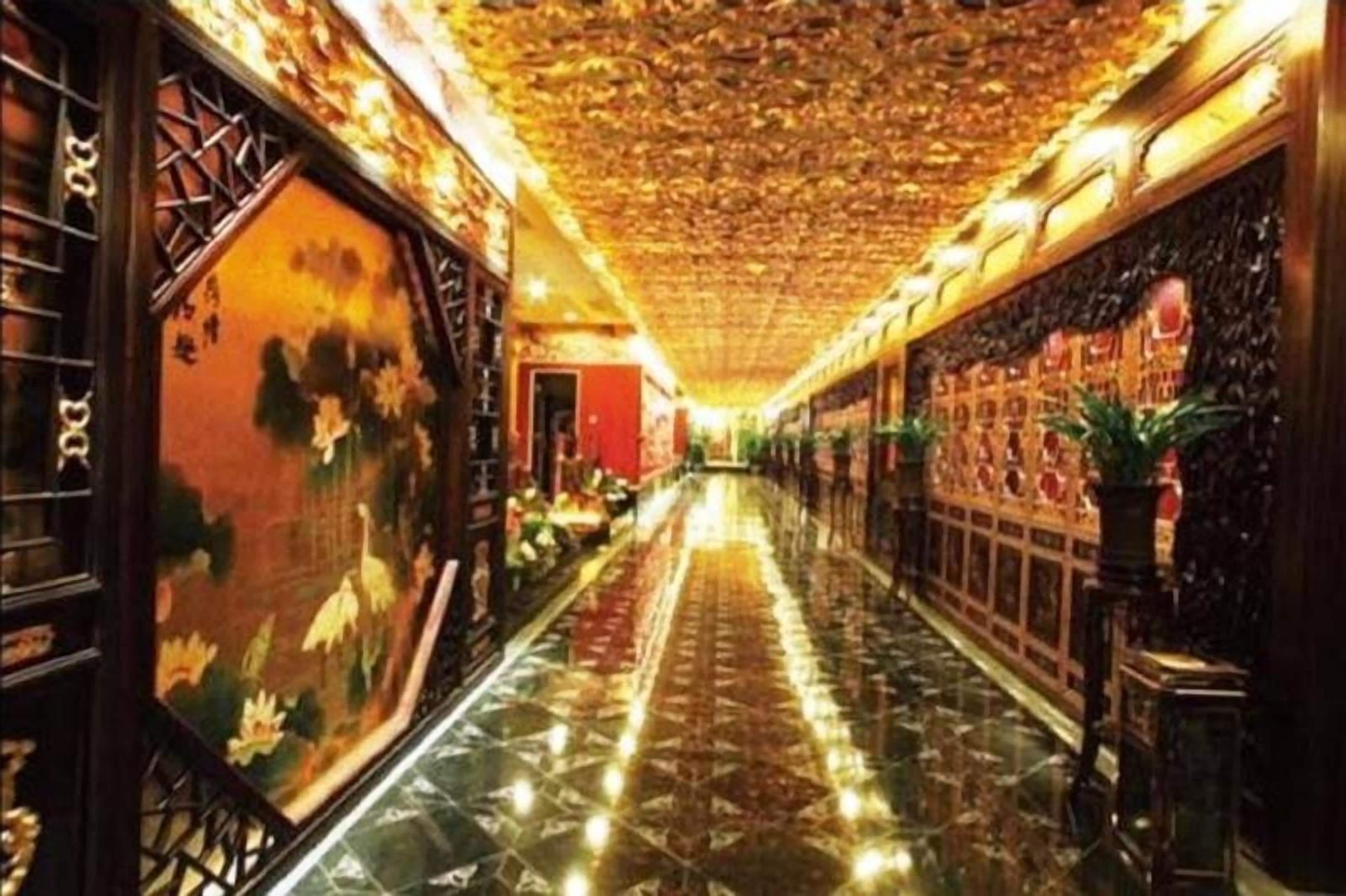 A corridor with a tiled floor, a patterned ceiling, and traditional wall decorations.