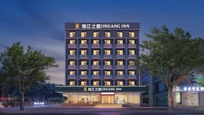 Un hôtel à plusieurs étages, doté d’une façade moderne, de nombreux balcons et d’une entrée bien éclairée.