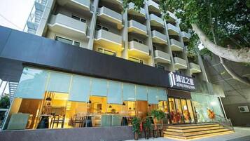 A hotel with a modern facade, a visible entrance, and a staircase leading to the entrance.