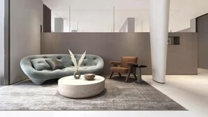 Un intérieur moderne avec un canapé, une table basse ronde et un fauteuil.