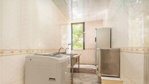 A compact kitchen with a washing machine, a sink, and a refrigerator. - Jilv Boutique Hotel (Guangzhou Shangxiajiu Pedestrian Street Xichang Subway Station) (GUANGZHOU)