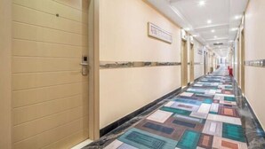A hotel corridor with beige walls, a patterned floor, and a ceiling with recessed lighting. - Jilv Boutique Hotel (Guangzhou Shangxiajiu Pedestrian Street Xichang Subway Station) (GUANGZHOU)