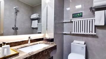 A bathroom with a sink, mirror, shower, and toilet.