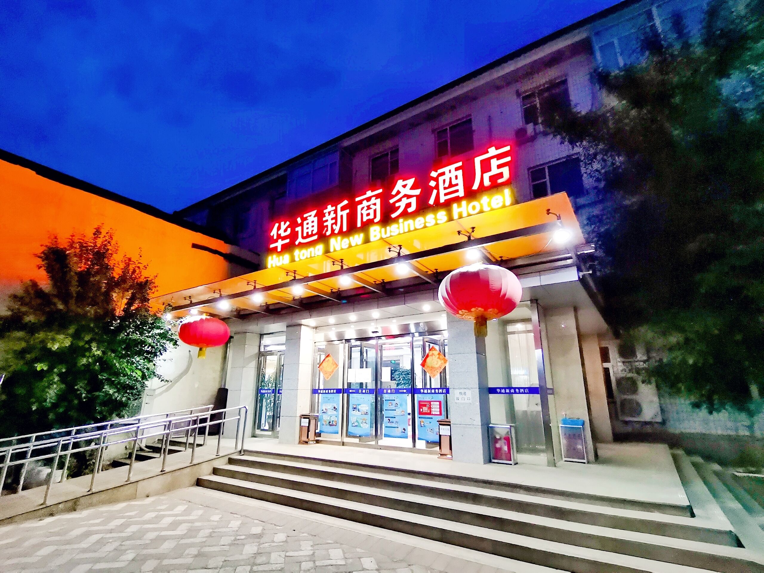 Entrada de un hotel con un letrero que dice "Hua tong New Business Hotel".