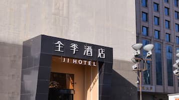 A hotel entrance with a large advertisement above.
