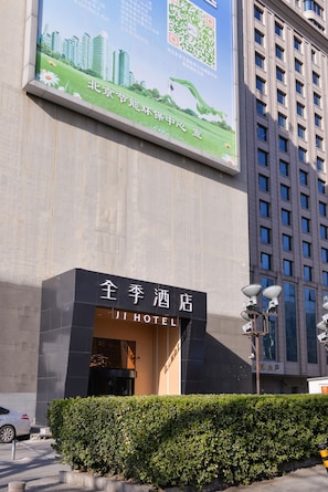 A hotel entrance with a large advertisement above. - Ji Hotel (Beijing)