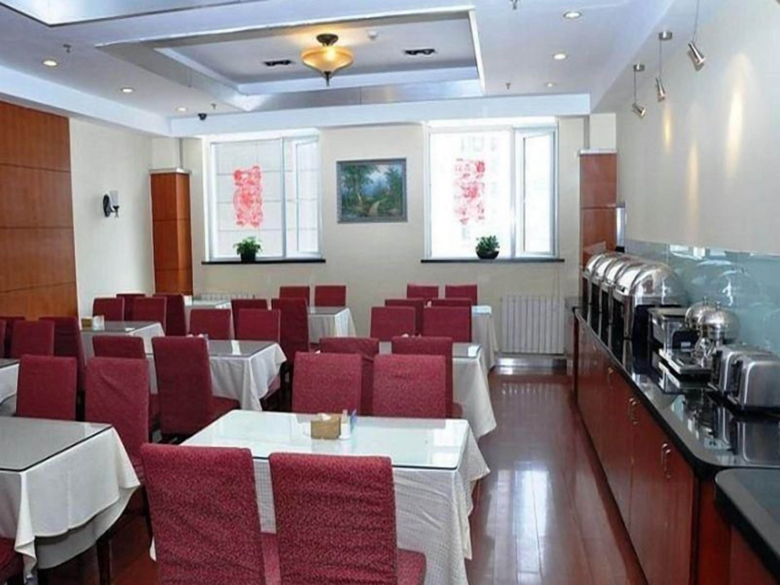 Sala de conferências com mesas, cadeiras, espaço para buffet e janela com vista.