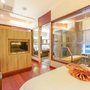 A modern hotel room with a wooden accent wall, a flat-screen TV, a large window with a view, and a neatly made bed. - Phoenix Hotspring Resort (Suzhou)