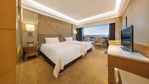 A hotel room with two beds, a desk, a TV, and a view of the city. - Shanghai HongQiao Airport Hotel (Shanghai)