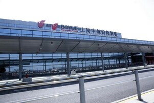 A modern building with a large glass facade and a covered walkway.