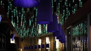 A bar area with a long counter and multiple blue hanging lamps. - Shanghai HongQiao Airport Hotel (Shanghai)