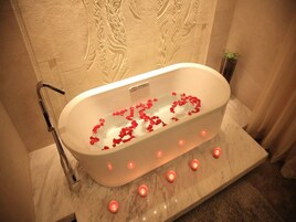 Una vasca da bagno con petali di rosa e candele.
