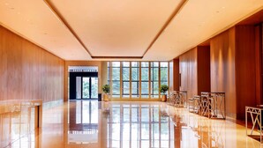 A spacious lobby with a polished floor, large windows, and wooden paneling. - Preess Resort Hotel (Changsha)
