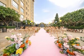 An outdoor wedding aisle with floral arrangements and chairs. - Santavan Hotel (Shenzhen)