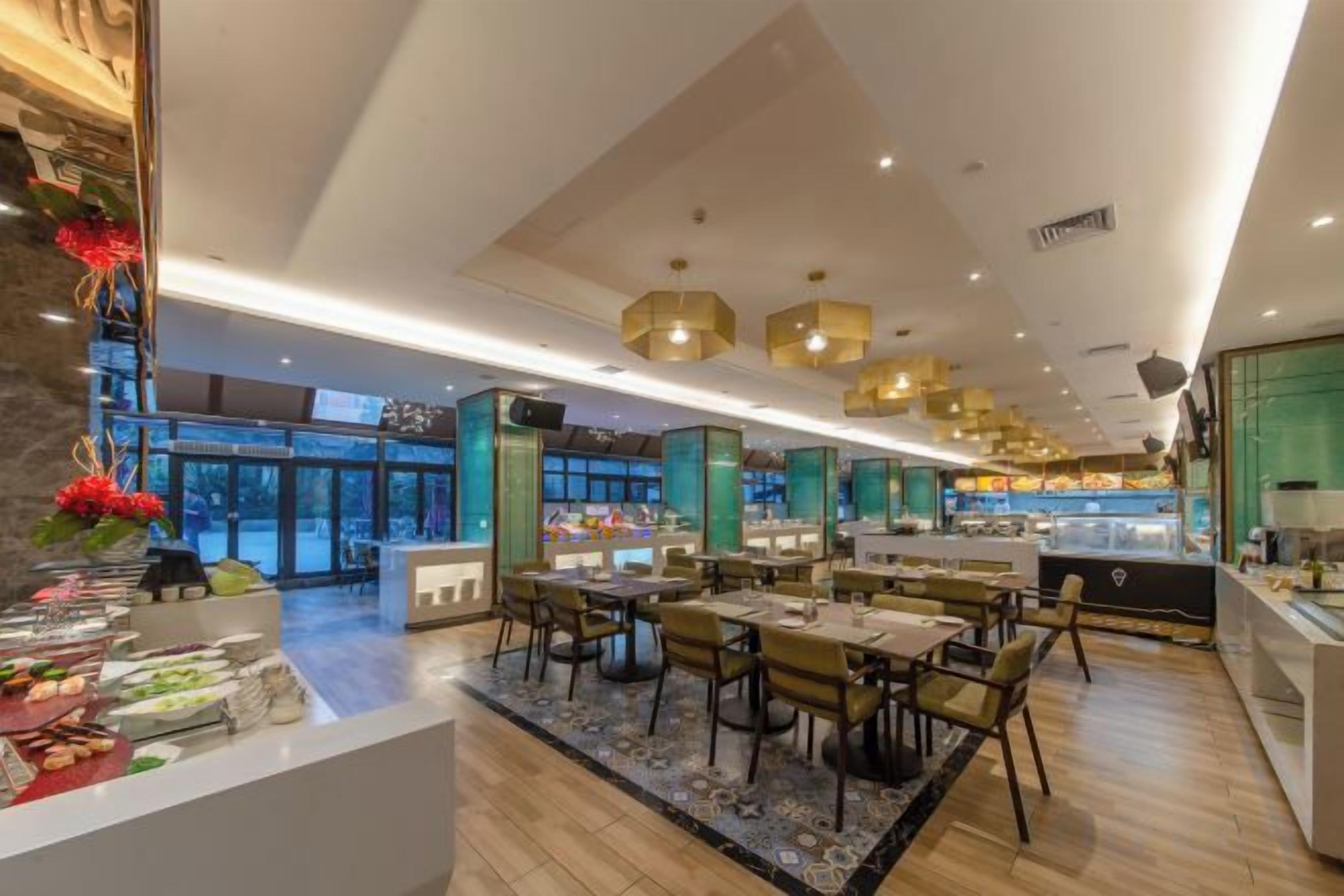 A spacious restaurant with multiple dining areas, a central counter, and a view of the outside.