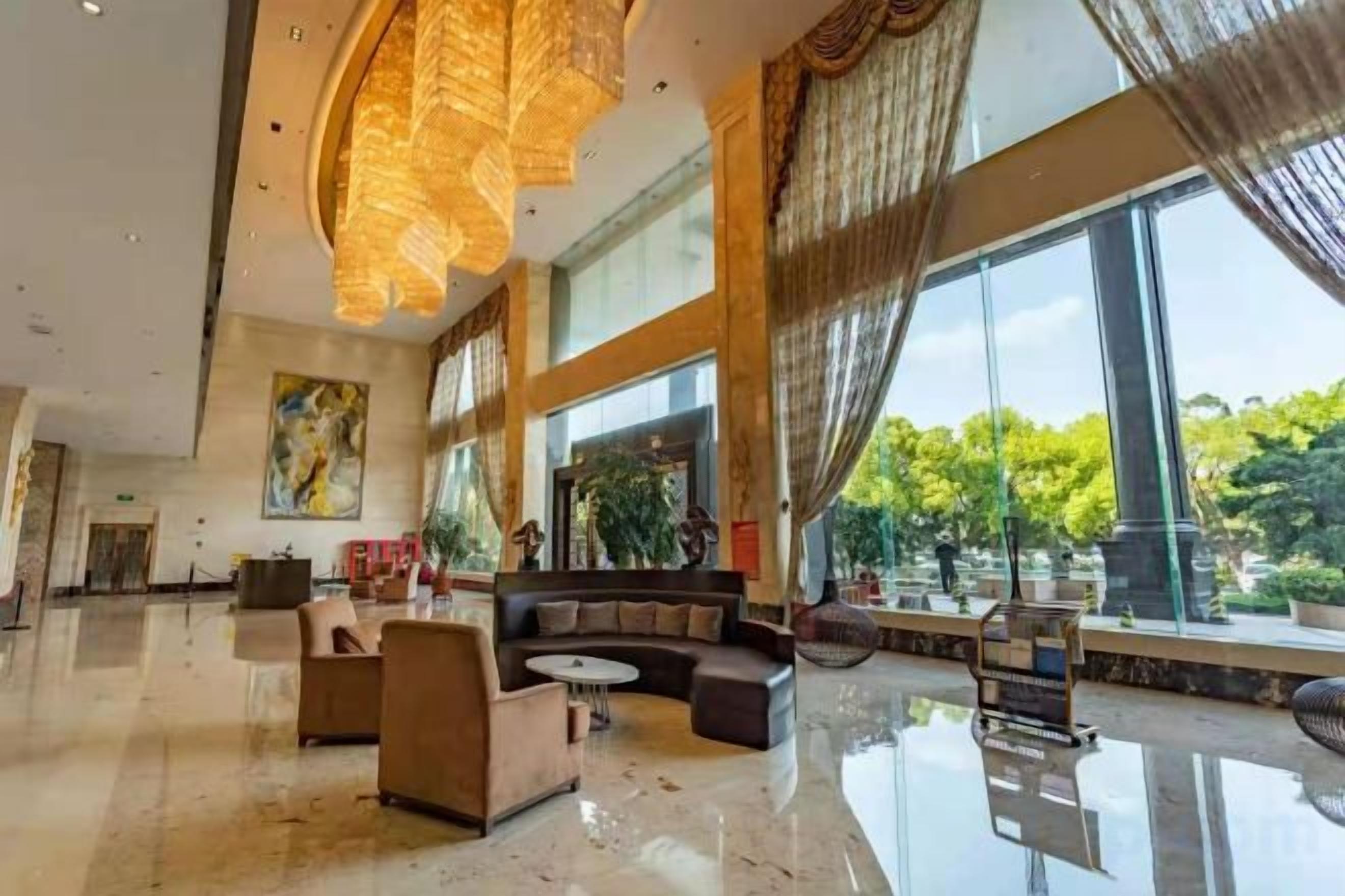 A spacious lobby with a high ceiling, large windows, and a seating area.