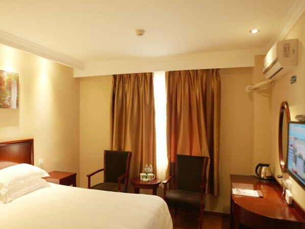 A hotel room with a bed, two chairs, a small table with a kettle and a cup, and a TV on a desk. - GreenTree Inn Zhenjiang Gaotie Wanda Square Express Hotel (Zhenjiang)