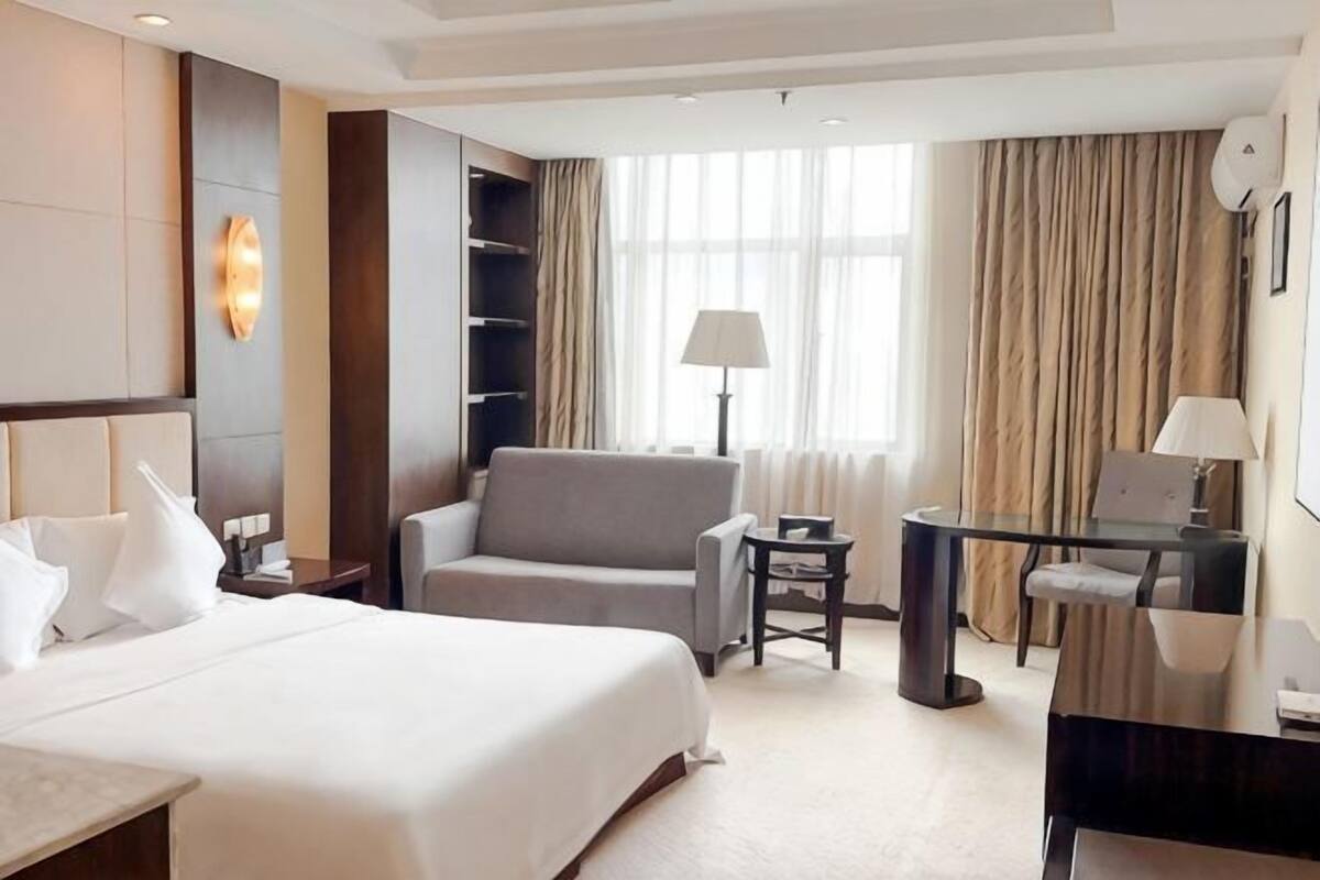 Ein Hotelzimmer mit einem großen Bett, einem Schreibtisch, einem Stuhl und einer Couch.